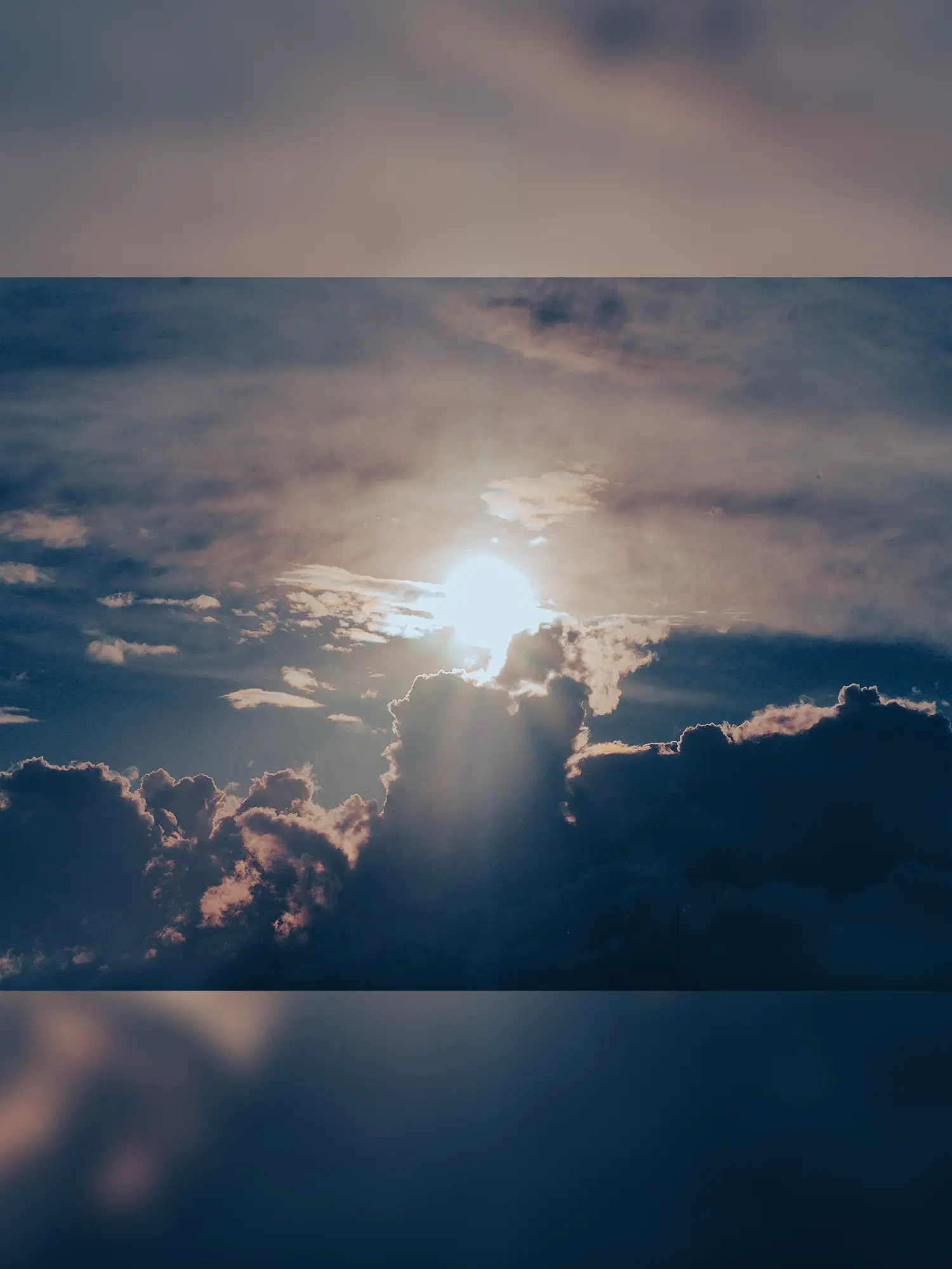 A rising sun peeking thru the clouds